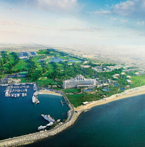 Das JA Palm Resort in Dubai von der Vogelperspektive. Es ist der Golfplatz und die drei Hotels zu sehen inkl. der Hafen